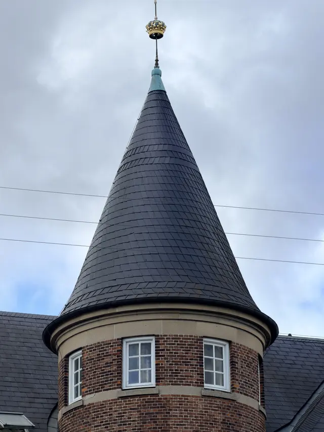 A corner turret under a conical slate roof.