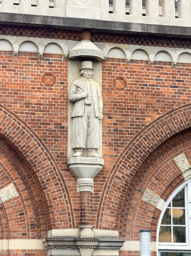 A stone figure of a man from Amager, set in the facade.