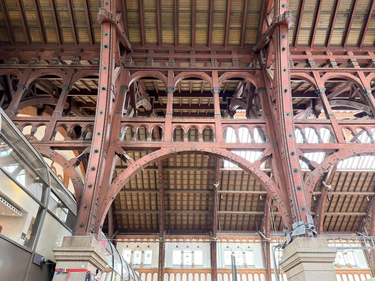 The main hall roof from below: curved timber ribs, diagonal braces, and rooflights between them.