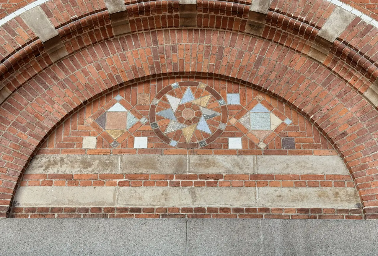 A brick tympanum laid as a star in alternating stone.