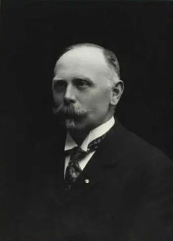 Black-and-white studio portrait of a man in his early fifties in a dark suit with a patterned tie.