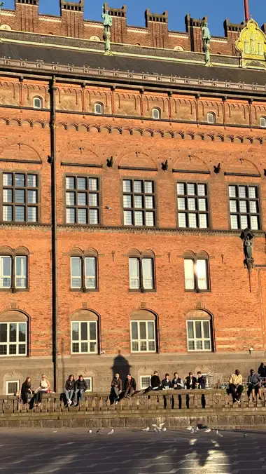 Billede af facade fag med ornamenteret tagfod tagrende set fra pladsen, i tegl, mørtel, natursten og skifer.