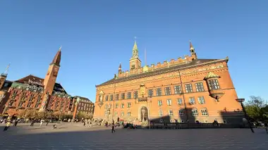 Oversigtsbillede af hel front tværs over  åben plads set fra pladsen, i tegl, mørtel, granit og skifer.