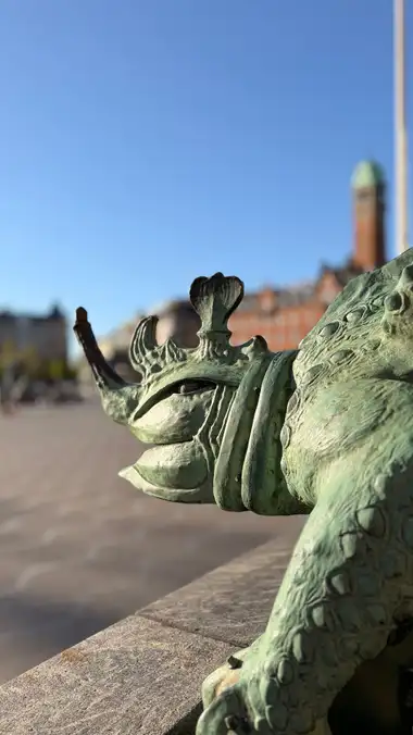 Nærbillede af kronet terrasse dyr i profil set fra pladsen, i kobber og granit.