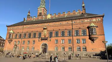 Oversigtsbillede af hoved front hel facade set fra pladsen, i tegl, mørtel, granit og skifer.