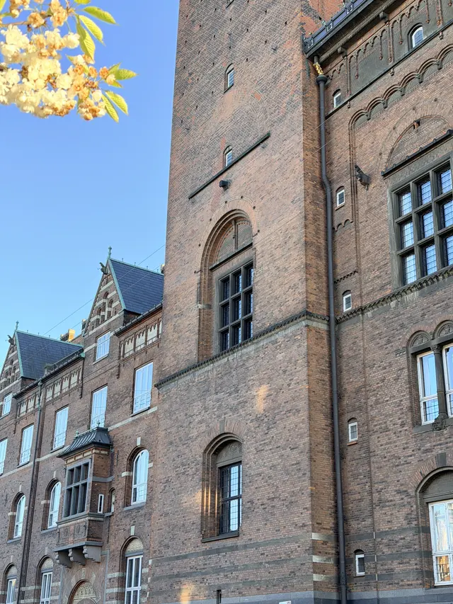 Billede af tårn møde  mellem bygning på gadefacaden, i tegl, mørtel, granit og natursten.