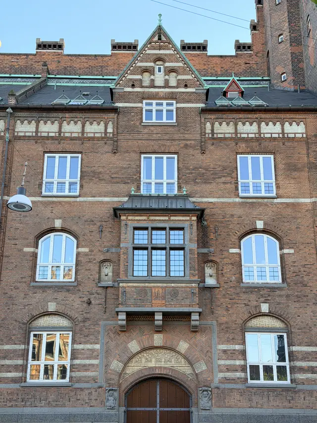 Billede af portåbning fag med terrakotta våben på gadefacaden, i tegl, mørtel, granit og natursten.