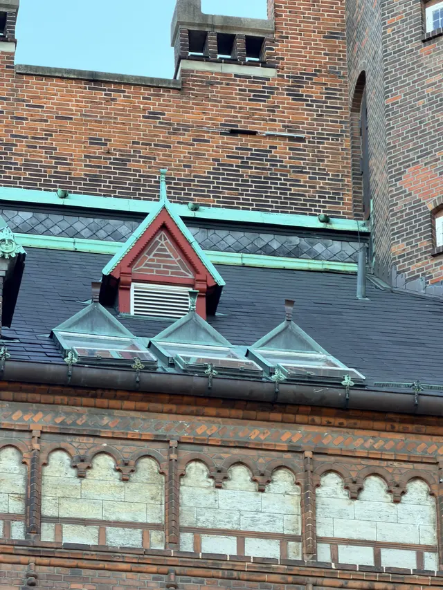 Billede af skifer tag med ventil kvist og tinde aftræk i gården, i skifer, tegl, mørtel og træ.