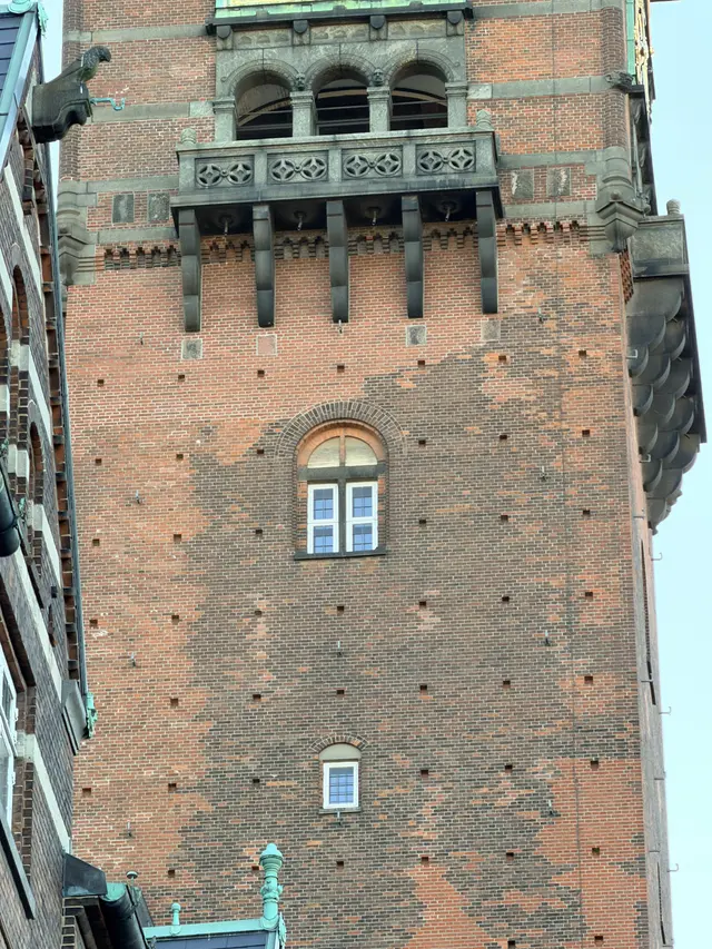 Billede af tårn galleri med udskåret hoveder i gården, i tegl, mørtel, granit og kobber.