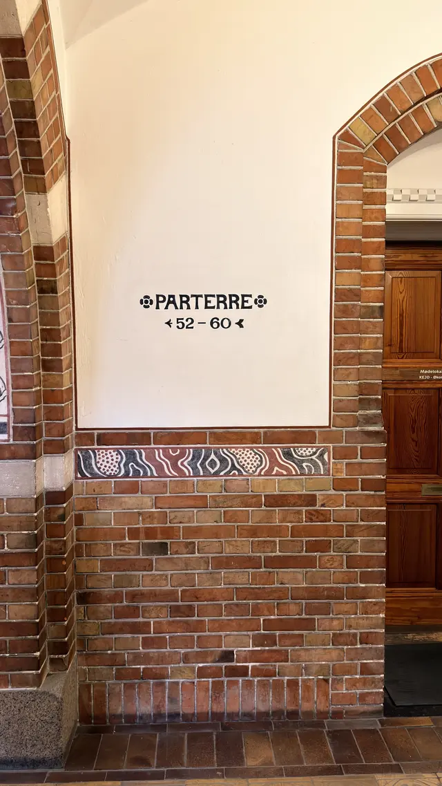 Billede af flerfarvet murværk med malet retnings skilt i korridoren, i puds, tegl, mørtel og fliser.