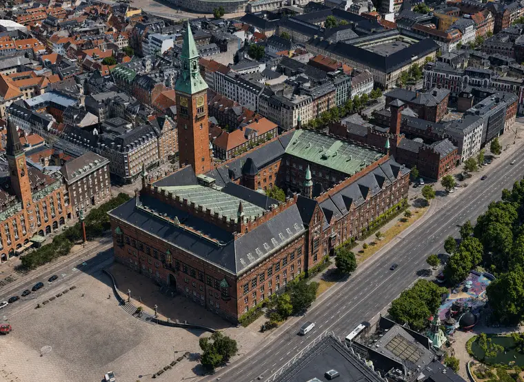 Københavns Rådhus set skråt fra luften med tårn, gårdrum og tagflader mellem Rådhuspladsen og H.C. Andersens Boulevard.
