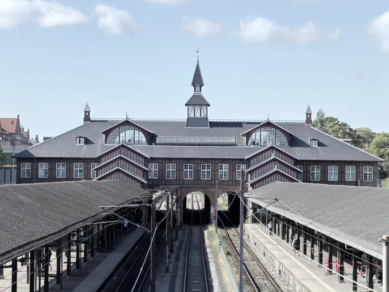 The station end-on from the bridge to the north: lunette gables, striped gables and tracks running in under the middle of the house.