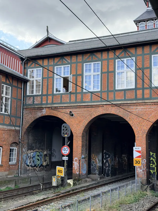 Brick arches under the timber-framed upper storey, with tracks running in under the building.