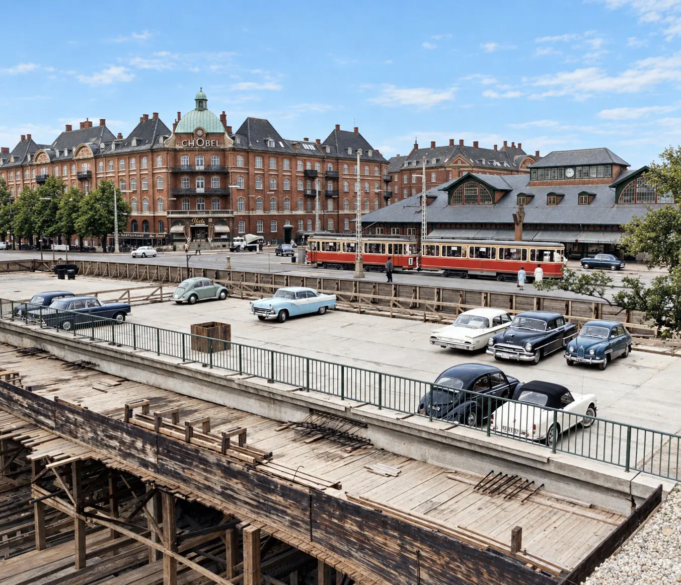 Oslo Plads in 1961: a tram, parked cars and the station behind with a low box in place of the spire.