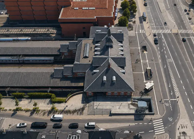 The historic station building seen almost vertically from above, with its slate roof, tower, platforms, tracks and surrounding streets.