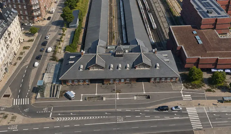 The station building seen obliquely from above with slate roofs, its street frontage, platforms and railway tracks.
