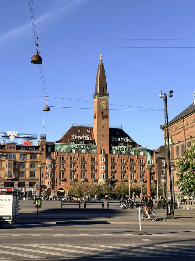 Hele facaden mod Rådhuspladsen set forfra: ni fag i midten om det centrale tårn, og et fremspringende endefag med buet front i hver ende.