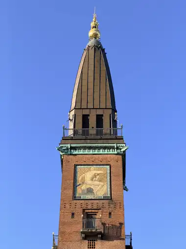 Billede af palace hotel tårn set fra pladsen, i tegl, kobber, glas og jern.