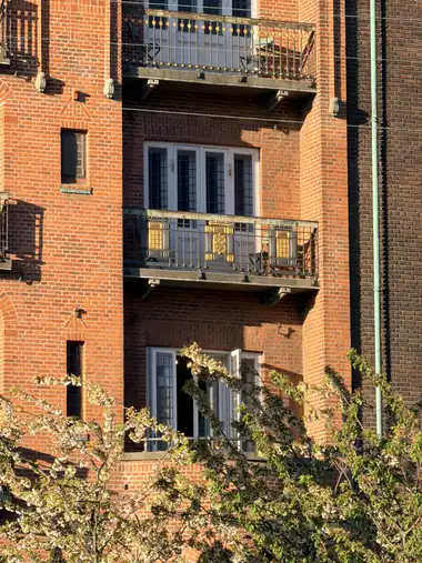 Billede af altan facade fag på gadefacaden, i tegl, mørtel, træ og glas.