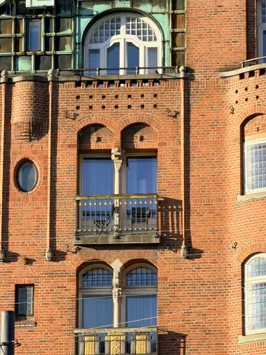 Billede af midterste altan facade fag på gadefacaden, i tegl, natursten, træ og glas.
