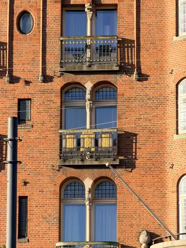 Billede af rigt dekoreret altan facade fag på gadefacaden, i tegl, mørtel, natursten og jern.