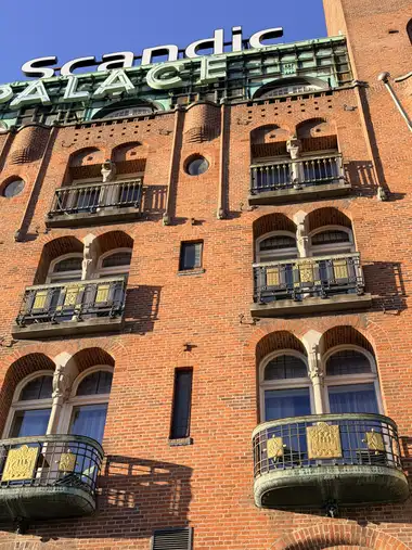 Billede af palace hotel altan fag på gadefacaden, i tegl, natursten, jern og metal.