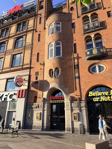 Billede af palace hotel indgang fag på gadefacaden, i tegl, granit, natursten og træ.