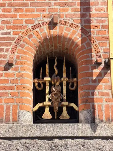 Billede af dekorativ vindue gitter på gadefacaden, i tegl, mørtel, granit og jern.