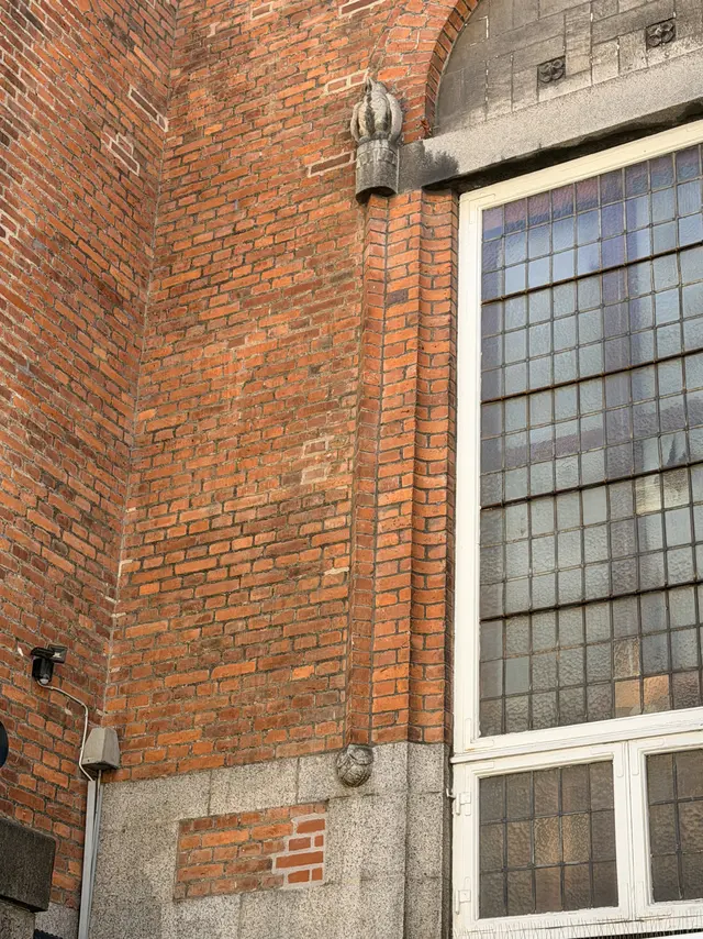 Nærbillede af den røde blanke mur med tynde, lyse fuger.