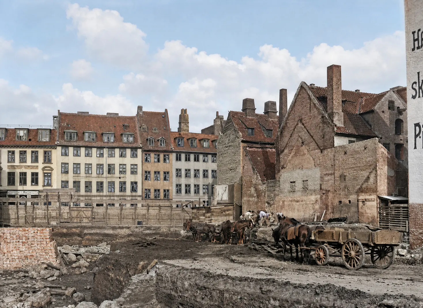 Byggegrunden på Rådhuspladsen i 1907: udgravning, stablede mursten, arbejdere og hestevogne foran nabohusenes blottede brandgavle.