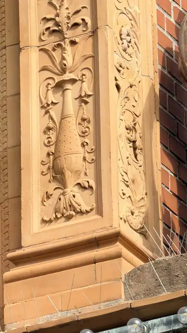 Nærbillede af terrakotta pilaster relief ved sidebygningen, i tegl, mørtel og stål.