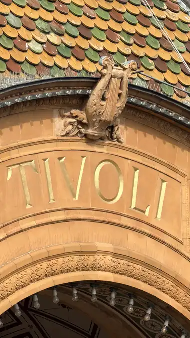 Nærbillede af terrakotta lyre kam langs facaden, i glas og metal.