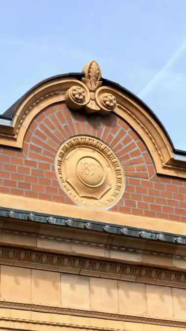 Nærbillede af pavillon 1890 dato sten ved sidebygningen, i tegl, mørtel, natursten og metal.