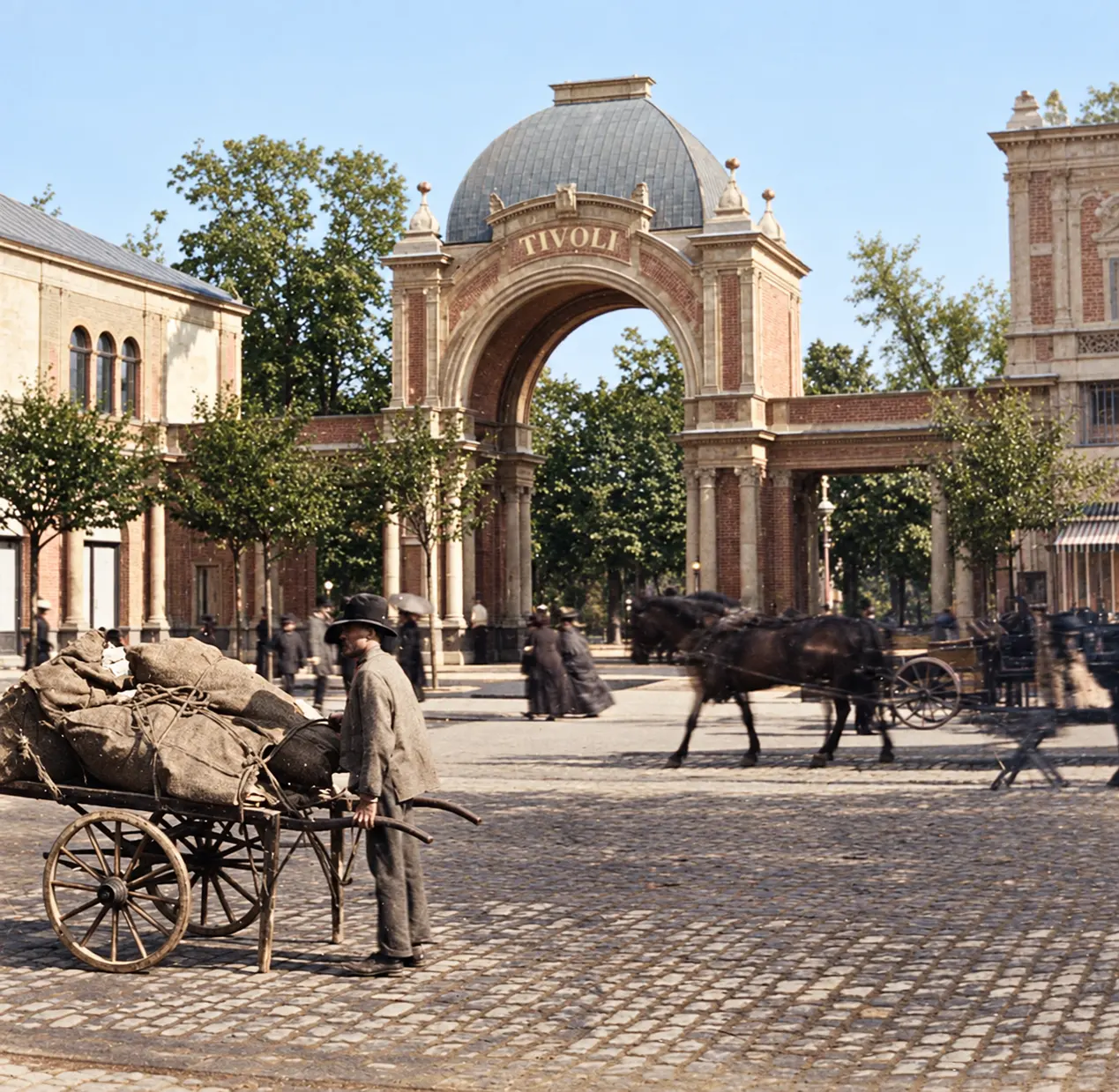 Porten fra 1890 set fra Vesterbrogade: kuplen, TIVOLI på buen, de lave arkader og en pavillon til højre; foran en mand med en trækvogn læsset med sække.